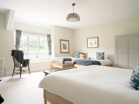 A bedroom with two beds and a window at Holwell Farmhouse in Bampton