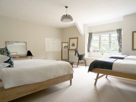 A bedroom with two beds and a chair at Holwell Farmhouse in Bampton