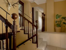 A staircase with wooden handrail and plant at Holwell Farmhouse in Bampton