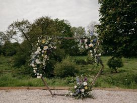 A decorative arch with flowers in a grassy area at Holwell Farmhouse in Bampton