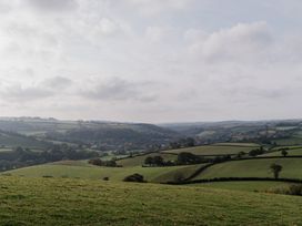 A landscape view of rolling hills and a village at Holwell Farmhouse in Bampton