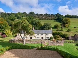 A house with a garden and tree at Holwell Farmhouse in Bampton