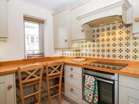 A kitchen with cabinets and bar stools at 11 Tram Lane in Kirkby Lonsdale
