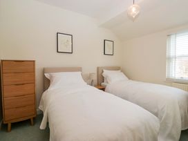 A bedroom with two beds and a chest of drawers at 11 Tram Lane in Kirkby Lonsdale