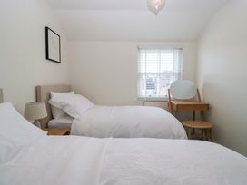 A bedroom with two beds and a dressing table at 11 Tram Lane Kirkby Lonsdale
