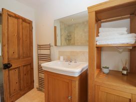 A bathroom with a sink, towel rack, and shelves at 11 Tram Lane in Kirkby Lonsdale