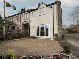 A house with a patio and potted plants at Tram Lane Cottage in Kirkby Lonsdale