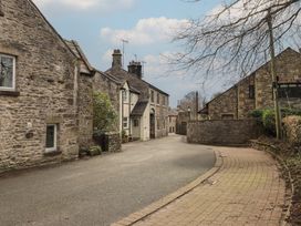 A street with stone buildings and trees at Tram Lane Cottage in Kirkby Lonsdale
