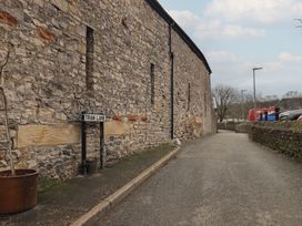 A stone wall with a sign for Tram Lane in Kirkby Lonsdale