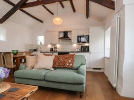 A living room with a sofa and kitchen units at Garreg Fawr