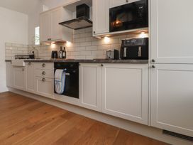 A kitchen with cabinets sink and appliances at Garreg Fawr