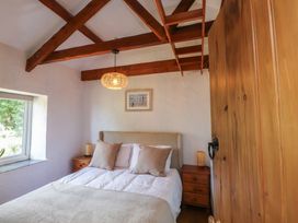 A bedroom with a bed and wooden furniture at Garreg Fawr
