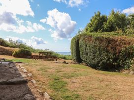 A garden with a picnic table and sea view at Garreg Fawr