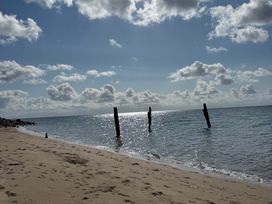 A beach with wooden posts in the water at Garreg Fawr in Llanbedrog