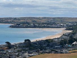 A view of a beach with houses and land at Garreg Fawr in Llanbedrog