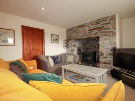 A living room with a sofa and a fireplace at Rosewin Farmhouse near St Minver