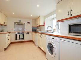 A kitchen with cabinets, oven, sink, and appliances at Rosewin Farmhouse near St Minver
