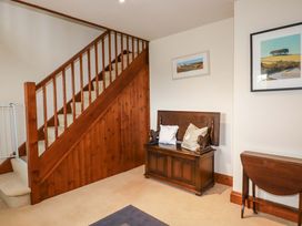 A hallway with a staircase and bench at Rosewin Farmhouse near St Minver
