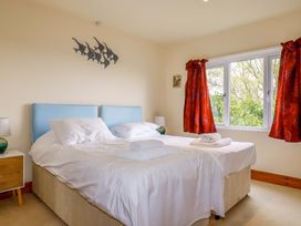 A bedroom with two beds and a window at Rosewin Farmhouse near St Minver