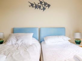 A bedroom with two single beds and a lamp at Rosewin Farmhouse near St Minver