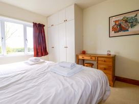 A bedroom with a bed and a desk at Rosewin Farmhouse near St Minver