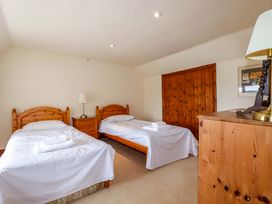 A bedroom with two beds and a nightstand at Rosewin Farmhouse near St Minver