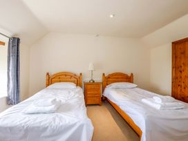 A bedroom with two beds and a nightstand at Rosewin Farmhouse near St Minver