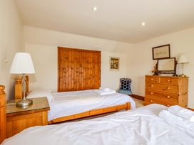 A bedroom with two beds and a dresser at Rosewin Farmhouse near St Minver