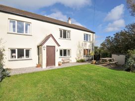 A house with a garden and seating area at Rosewin Farmhouse near St Minver