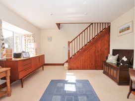A living room with a sideboard and staircase at Rosewin Farmhouse near St Minver