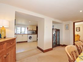 A dining room with a sideboard and a view into the kitchen at Rosewin Farmhouse near St Minver