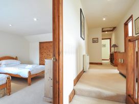 A bedroom with a bed and an adjoining hallway at Rosewin Farmhouse near St Minver