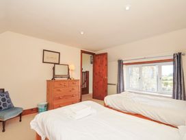 A bedroom with two beds and a dressing table at Rosewin Farmhouse near St Minver