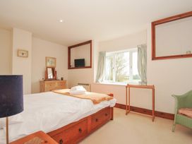 A bedroom with a bed, dresser, and television at Rosewin Farmhouse near St Minver