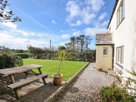 A garden with a picnic table and flower planter at Rosewin Farmhouse near St Minver