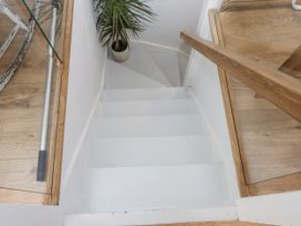 Stairs leading down with a plant and wooden railing at The Workshop in Mary Tavy