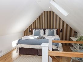A bedroom with a bed and shelf at The Workshop in Mary Tavy