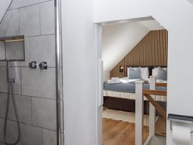 A shower and a bed in an attic space at The Workshop in Mary Tavy