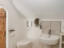 A bathroom with a toilet, sink, and mirror at The Workshop in Mary Tavy