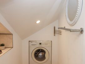 A laundry room with a washing machine and mirror at The Workshop in Mary Tavy