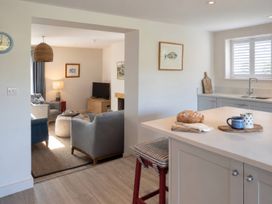 A kitchen with a view of the living area at Wood Cottage