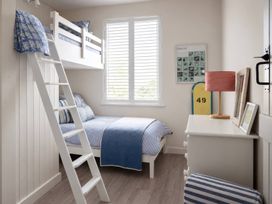 A bedroom with a bunk bed and a single bed at Wood Cottage