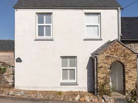A facade of a house with windows and a stone archway at Wood Cottage