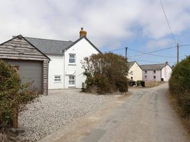 A house and garage on a gravel driveway at Wood Cottage