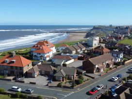 A view of houses and beach near the ocean at Roseberry in Whitby