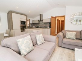 A living room with sofas and a dining area at Easedale Lodge, Waterside Wood 2, White Cross Bay near Windermere