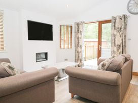 A living room with a television and sofa at Easedale Lodge Waterside Wood 2 White Cross Bay near Windermere