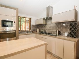 A kitchen with a microwave and oven at Easedale Lodge, Waterside Wood 2, White Cross Bay near Windermere