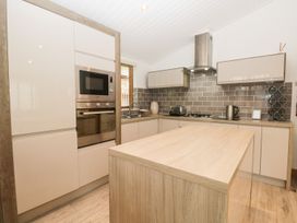 A kitchen with cabinets and appliances at Easedale Lodge Waterside Wood 2 White Cross Bay near Windermere