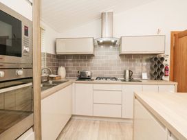 A kitchen with oven, sink, kettle, and toaster at Easedale Lodge Waterside Wood 2, White Cross Bay near Windermere